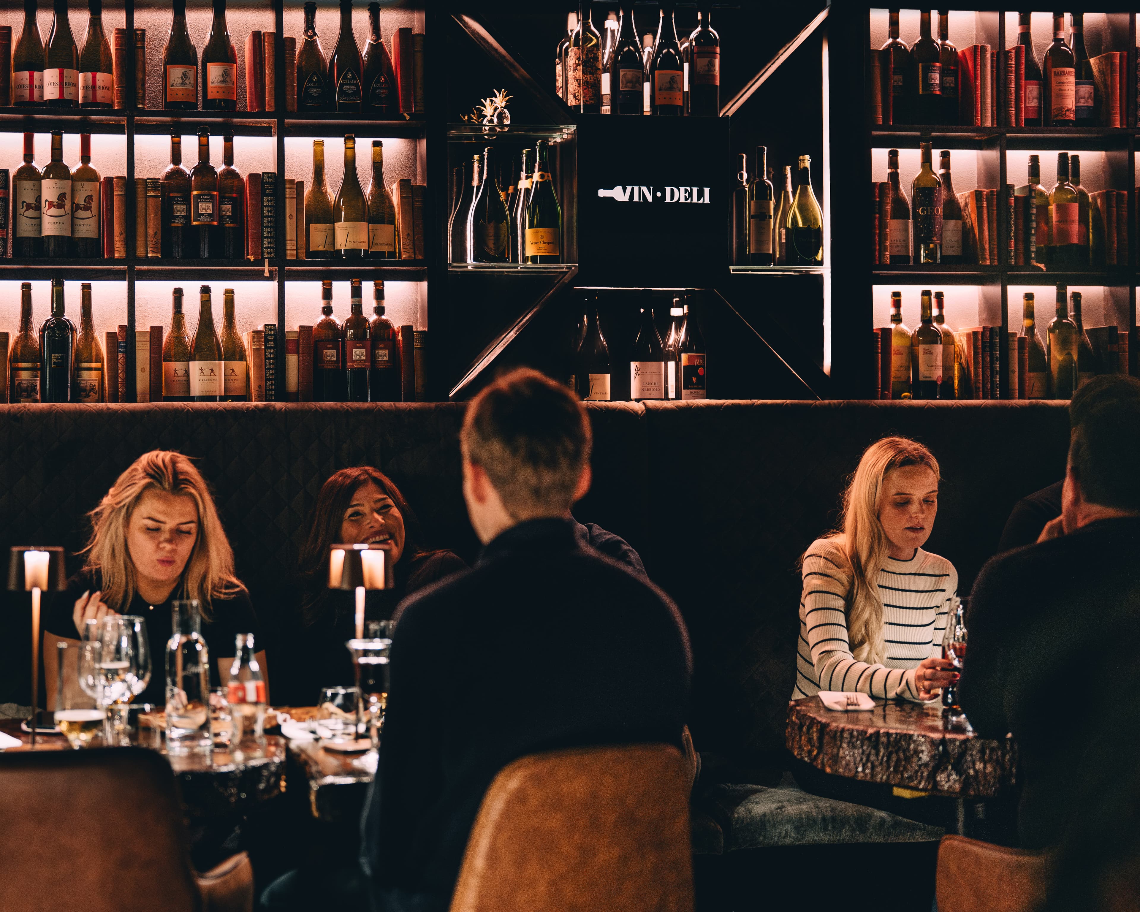 Vinflaskor och gäster på Vin O Deli